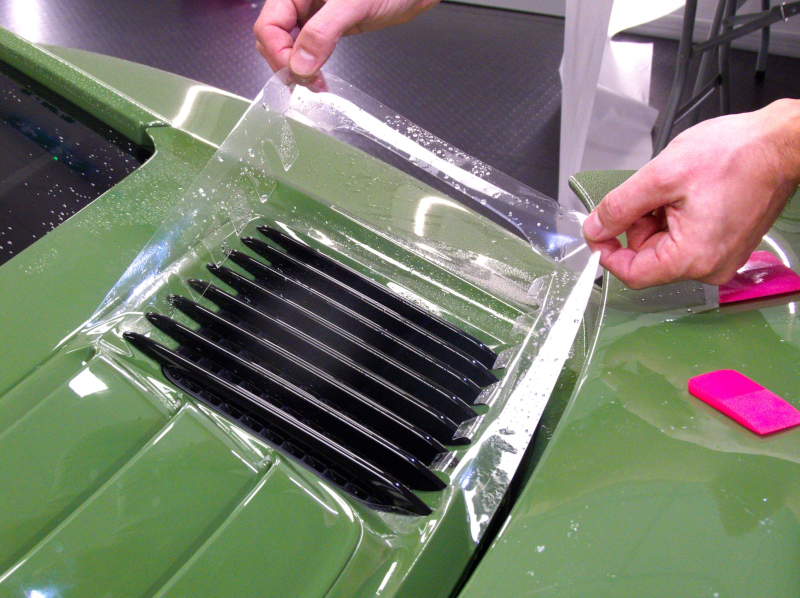 posizionamento pellicola adesiva per auto su dettaglio baule porsche